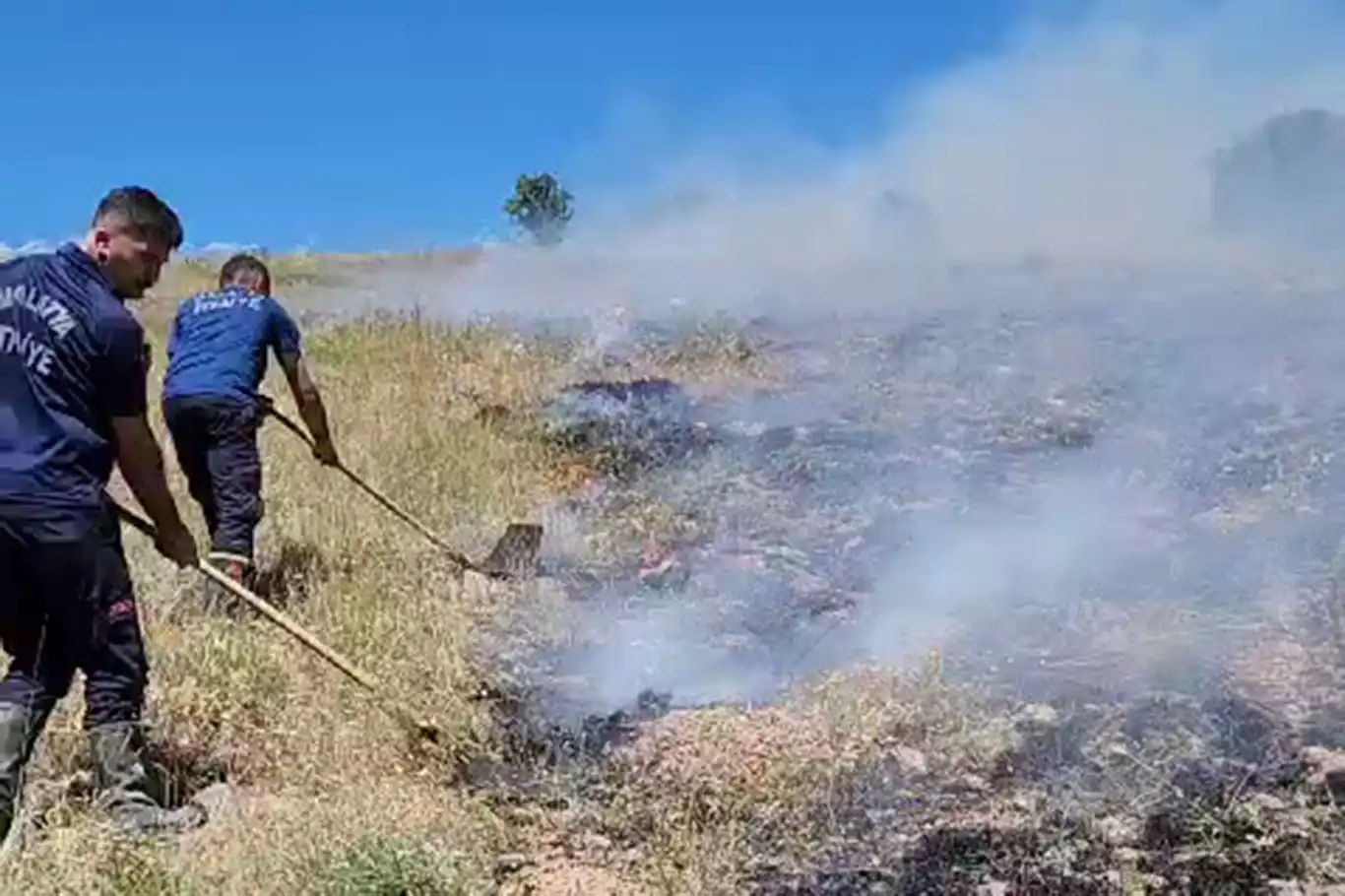 Dağlık alanda yangın araçlarının giremediği bölgeye ekipler küreklerle müdahale ediyor